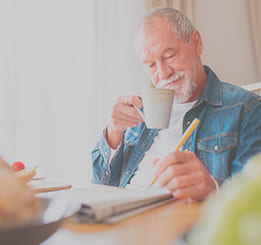 Senhor tomando café e lendo jornal