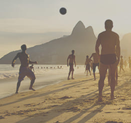 Homens jogando bola na praia