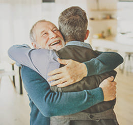 dois homens felizes se abraçando