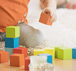 Criança brincando com brinquedo de blocos coloridos