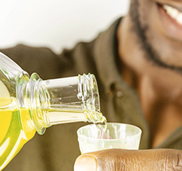 Homem afrodescendente colocando enxaguante bucal no medidor para utilizá-lo