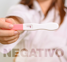 Mulher segurando teste de gravidez na mão com resultado negativo
